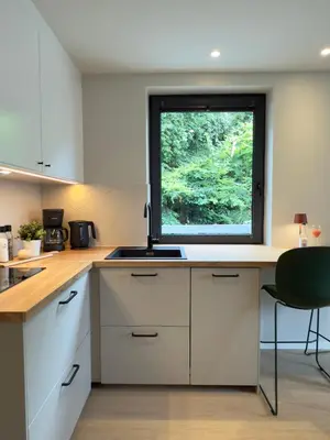 a kitchen with white cabinets and a window at Odda City Apartments in Odda