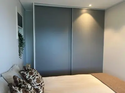 a bedroom with a bed with a blue wall at Fin leilighet med parkering! in Bergen
