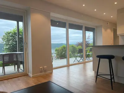a kitchen with a counter and glass doors with a view at Fin leilighet med parkering! in Bergen