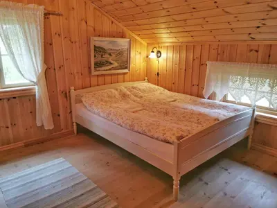 a bedroom with a bed in a wooden room at Unique farm stay in the steep mountains of Rjukan in Vemork