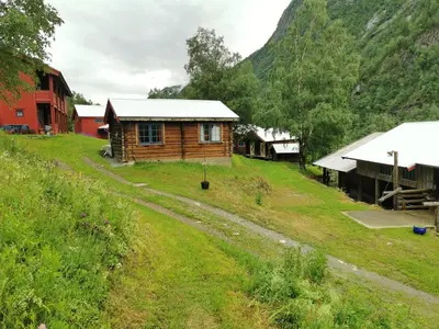 a small wooden cabin on a grassy hill at Unique farm stay in the steep mountains of Rjukan in Vemork