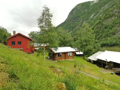a group of buildings on a hill next to a mountain at Unique farm stay in the steep mountains of Rjukan in Vemork