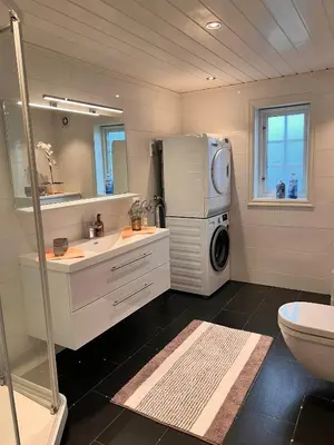 a bathroom with a sink and a washer and dryer at På solsiden av Gaustatoppen in Tuddal