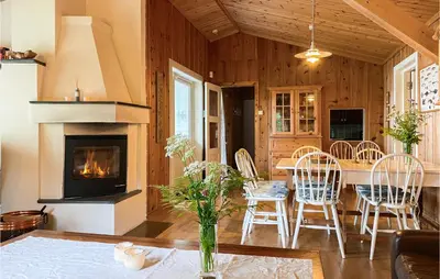 a living room with a fireplace and a table and chairs at 4 Bedroom Beach Front Home In Skodje in Skodje