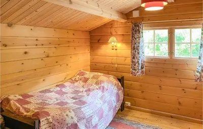 a bedroom with a bed in a log cabin at Nice Home In Selje With Wifi in Stokke