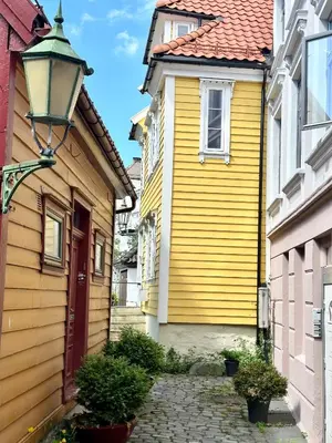 a yellow house with a street light in front of it at Knøsesmauet Apartment in Bergen
