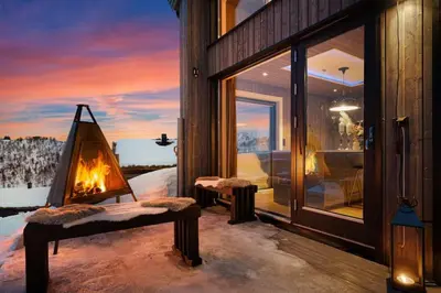 a fireplace sitting on a balcony of a house at Ski-in-out from the door Alpine XC Mountain views in Torvetjørn