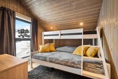 a bedroom with a bunk bed and a window at Ski-in-out from the door Alpine XC Mountain views in Torvetjørn