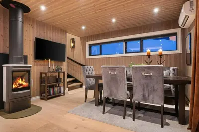 a dining room with a table and a fireplace at Ski-in-out from the door Alpine XC Mountain views in Torvetjørn