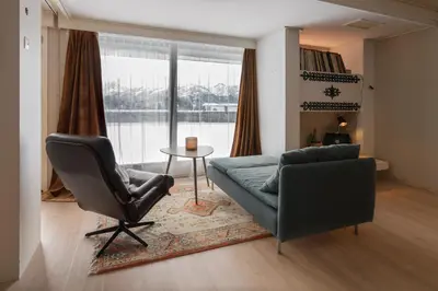 a living room with a couch and a chair and a table at Fjord view apartment in Ålesund with free parking in Ålesund