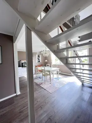 a dining room with a white table in a room with a staircase at Moldegaard Farmhouse - Apartment C in Moldegard