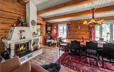 a dining room with a fireplace and a dining table at Nice Home In Svingvoll in Svingvoll