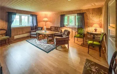 a living room with a table and chairs at Nice Home In Sagstua With Lake View in Linstad