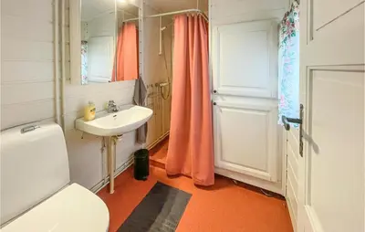 a bathroom with a white toilet and a sink at Nice Home In Sagstua With Lake View in Linstad