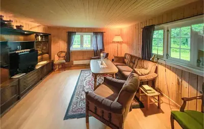 a living room with a couch and a tv at Nice Home In Sagstua With Lake View in Linstad