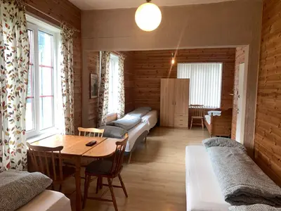 a living room with a table and a dining room at Fjordshelter dorm in Tysso