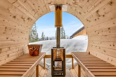 a stove in a wooden room with two benches at Private Room in Beautiful Mountain Home w/ Sauna in Beitostøl