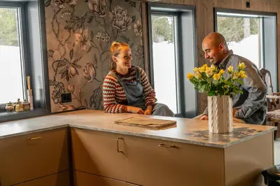 a man and a woman sitting at a table in a kitchen at Private Room in Beautiful Mountain Home w/ Sauna in Beitostøl