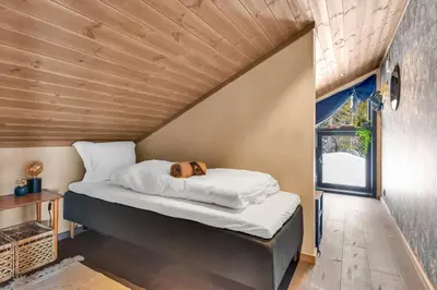 a dog laying on a bed in a room with a window at Private Room in Beautiful Mountain Home w/ Sauna in Beitostøl