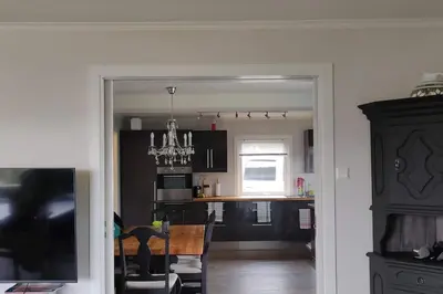 a kitchen with black cabinets and a chandelier in a room at Hus med utsikt på leira . 4 sengeplasser. in Leira