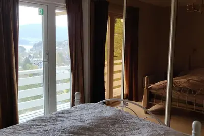 a bedroom with a bed and a large window at Hus med utsikt på leira . 4 sengeplasser. in Leira