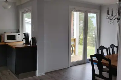 a dining room with a table and a microwave at Hus med utsikt på leira . 4 sengeplasser. in Leira