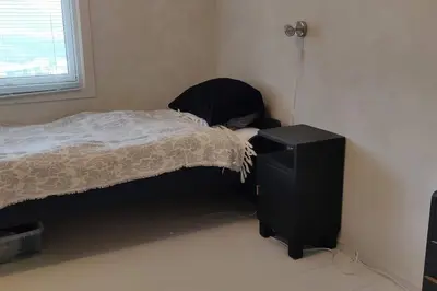a bedroom with a bed and a dresser next to a window at Hus med utsikt på leira . 4 sengeplasser. in Leira