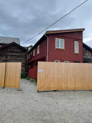 two wooden fences in front of a red house at Kjerkgata 6 - midt i Røros sentrum in Røros
