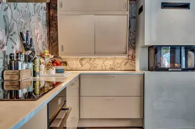 a kitchen with white cabinets and a refrigerator at Peaceful Oasis. Panoramic forest- & mountain view. Sauna. in Beitostøl