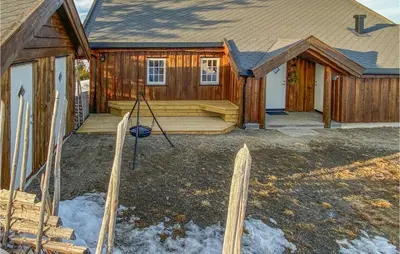 a log cabin with a porch and a house at 5 Bedroom Gorgeous Home In Sjusjøen in Sjusjøen