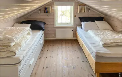 two beds in a small room with wooden floors at 5 Bedroom Gorgeous Home In Sjusjøen in Sjusjøen