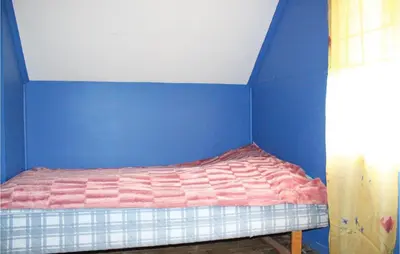 a bed in a room with a blue wall at Amazing Home In Dale I Sunnfjord in Gjølanger