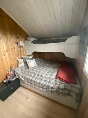 a bedroom with a bed in a wooden cabin at Luxurious, well-Equipped and modern Cabin by the Cross-Country Ski Trails in Eggedal