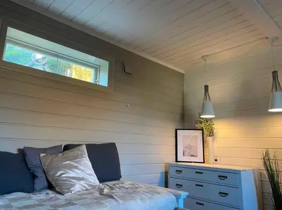 a bedroom with a bed and a window and a dresser at Cosy and well-equipped apartment with free parking in Trondheim