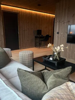 a living room with a couch and a table with a tv at Sogndal Chalet in Sogndal