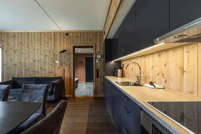 a kitchen with a sink and a living room at Leiligheter på Fyri Resort - Hemsedal in Hemsedal