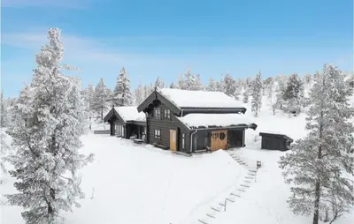 a log cabin in the snow with snow covered trees at 5 Bedroom Gorgeous Home In Tynset in Tynset