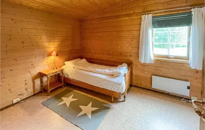 a bedroom with a bed in a wooden room at Gorgeous Home In Dovre With Wifi in Dovre
