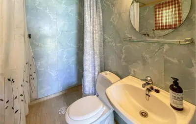 a bathroom with a sink and a toilet and a mirror at Gorgeous Home In Dovre With Wifi in Dovre