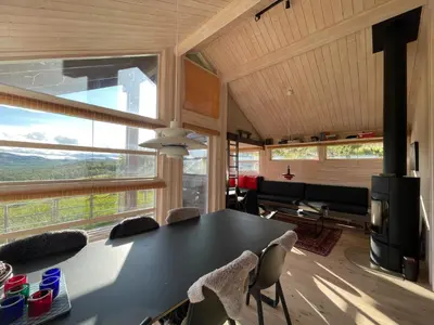 a dining room with a table and chairs and a large window at Veslestølen - Ålhytte with amazing view, 1000 meter in Ål