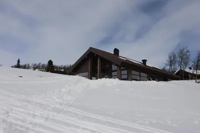 a ski lodge with a pile of snow in front of it at Veslestølen - Ålhytte with amazing view, 1000 meter in Ål