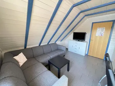 a living room with a couch and a tv at Nautnes Seaside Apartments A5 in Nautnes