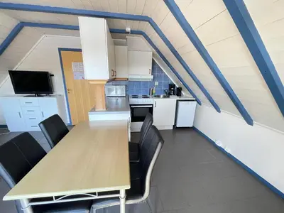a kitchen with a long wooden table and chairs at Nautnes Seaside Apartments A5 in Nautnes