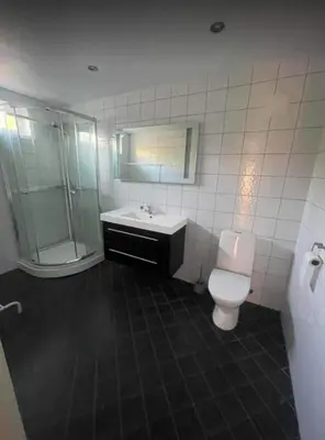 a bathroom with a toilet and a shower and a sink at Nautnes Seaside Villa in Nautnes