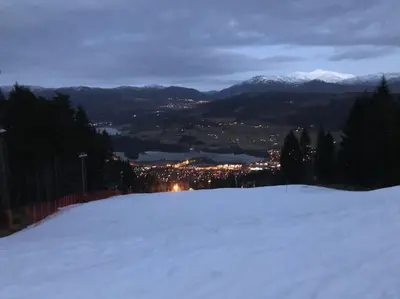 a snow covered slope with a city in the distance at Voss - Flott hytte i Bavallen in Skulestadmo