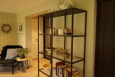 a black book shelf in a living room with books at Koselig leilighet i Langevåg in Holen