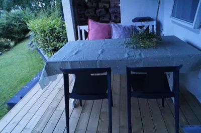 a table and two chairs on a deck at Koselig leilighet i Langevåg in Holen