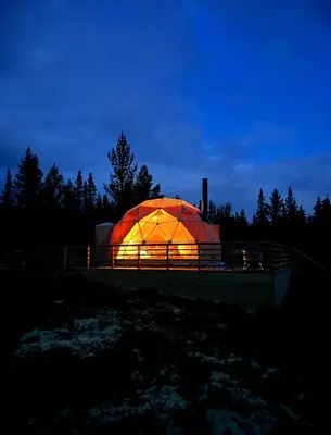 an orange dome is lit up at night at Arctic Dome Gudbrandsdalen in Sør-Fron