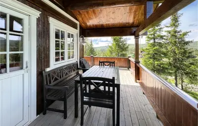 a wooden porch with a table and chairs on it at 4 Bedroom Beautiful Home In Nord-Torpa in Nord Torpa