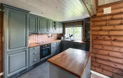 a kitchen with blue cabinets and a wooden counter top at 4 Bedroom Beautiful Home In Nord-Torpa in Nord Torpa